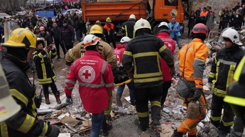 Volontärer och räddningsarbetare går bland ruiner, efter att ett bostadshus skadats i Odessa.