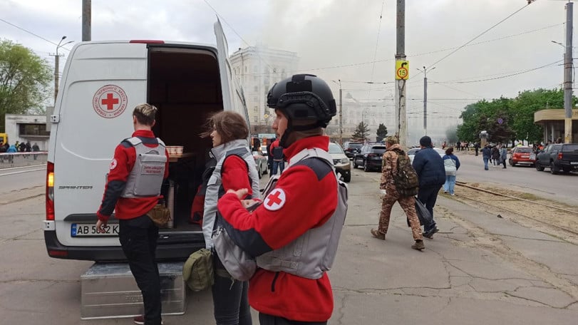 Tre volontärer från Röda Korset står vid en skåpbil och förbereder assistans åt drabbade i Dnipro.