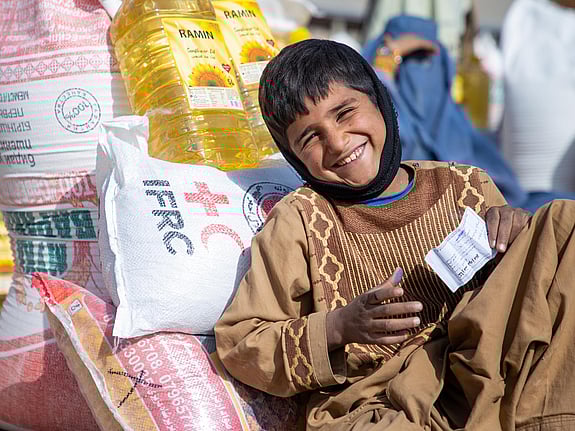 En pojke i flytväst med en räddningsarbetare i Indonesien