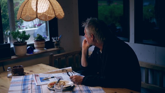 Ensam man vid köksbord