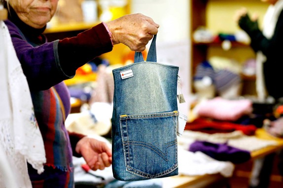 En-kvinna-håller-i-en-väska-som-är-gjord-av-ett-par-jeans