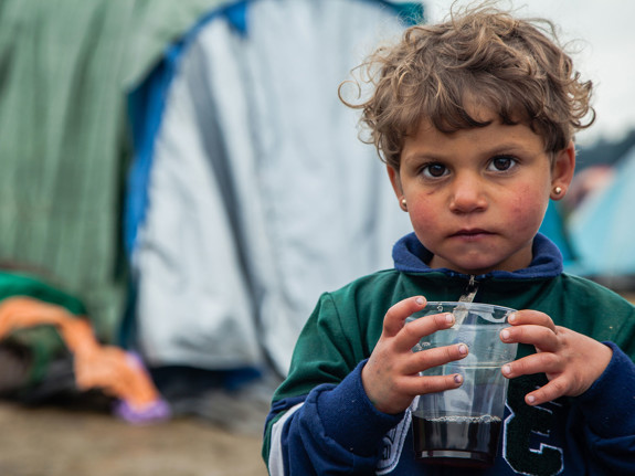 Flicka ler och tittar in i kameran