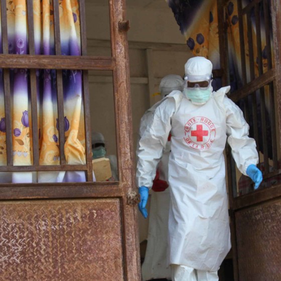 Ebolautbrott där vitklädd volontär hjälper.