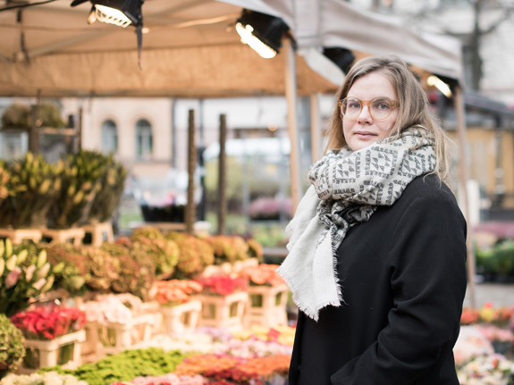 Johanna Lönn står på ett torg framför ett blomstånd.
