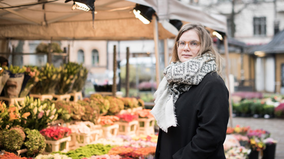 Johanna Lönn står på ett torg framför ett blomstånd.