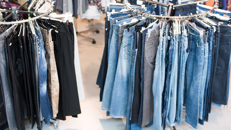 jeans-som-hänger-på-klädstång-i-butiken