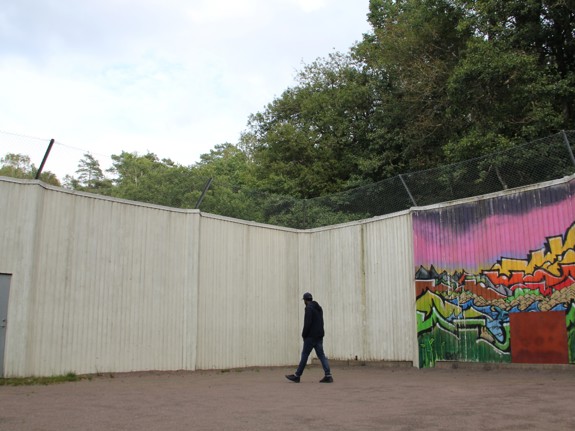 Ensam man går intill betongmur