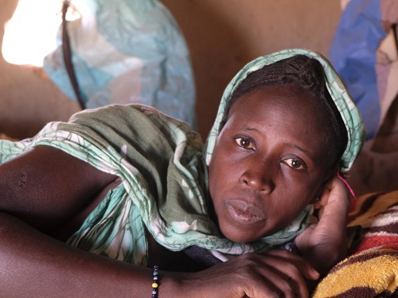 Kvinna i grön sjal tittar in i kameran