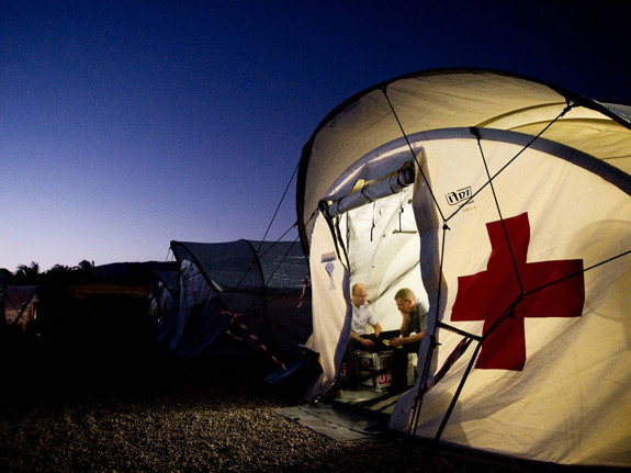 Upplyst tält med röda korset på.