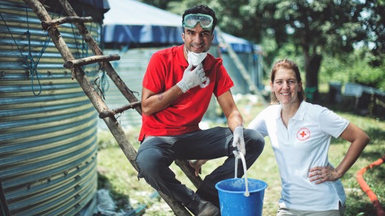 Farzad Farzaneh och Röda Korskollega framför vattenreningsverk i Uganda.