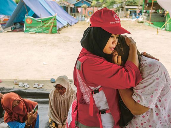 Volontär tröstar kvinna i kris.