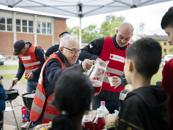 Sven-Erik Sjöstrand och Samir Makhlouf serverar korv och saft.