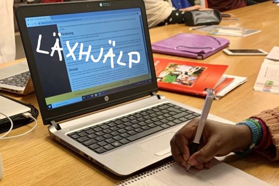 Bild på en datorskärm med texten läxhjälp och en hand som skriver i ett kollegieblock.