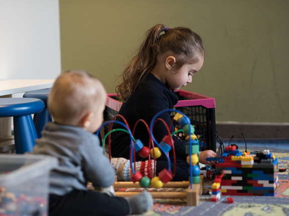 Barn leker med lego på lekmatta.