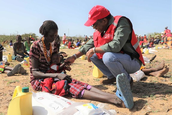 Volontär och kvinna vid matutdelning i Kenya