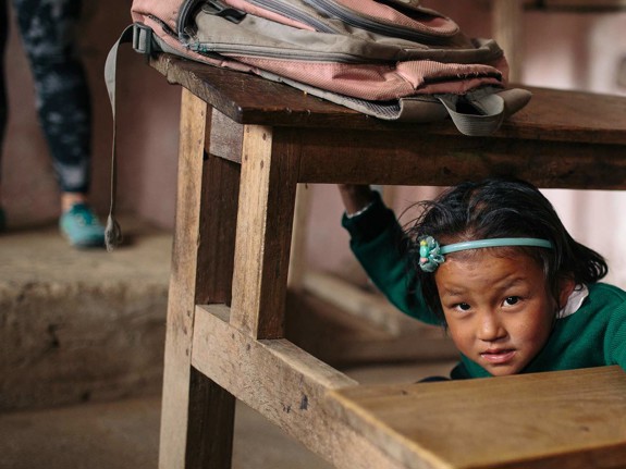 Flicka lär sig hur man skyddar sig vid en jordbävning