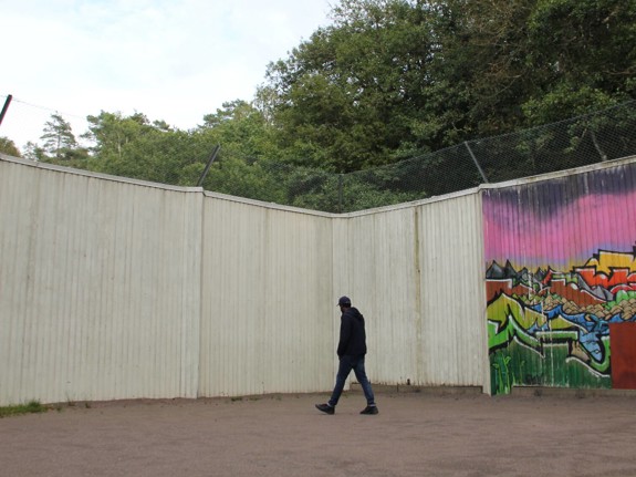 Person går innanför mur