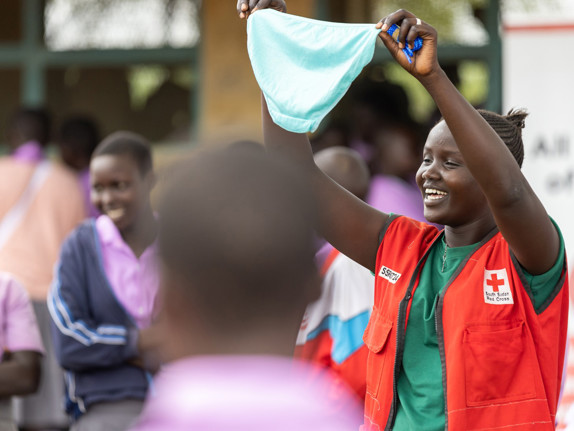 En volontär från Röda Korset håller upp en trosa framför skolelever i Sydsudan.