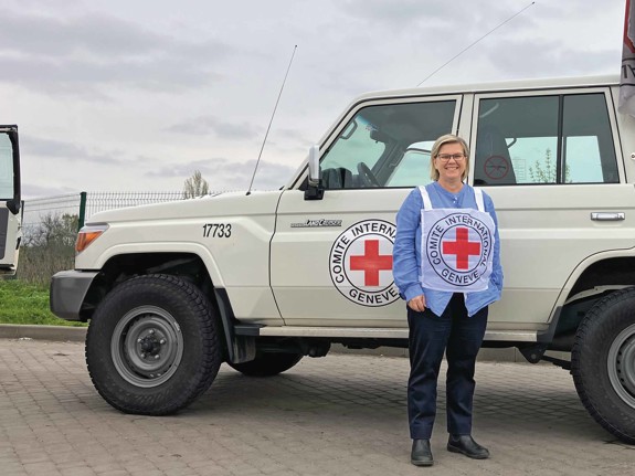 Karin Levenby bovy framför en bil från Röda Korset.