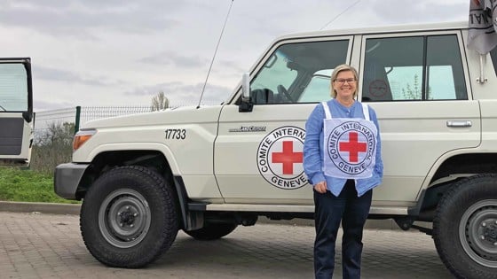 Karin Levenby Bovy framför en bil från Röda Korset.