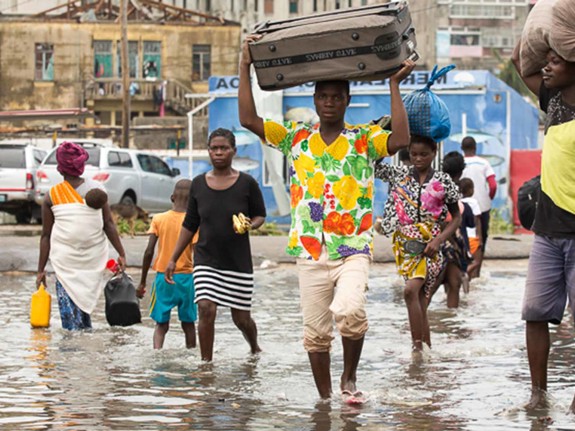 Människor flyr på översvämmad gata.