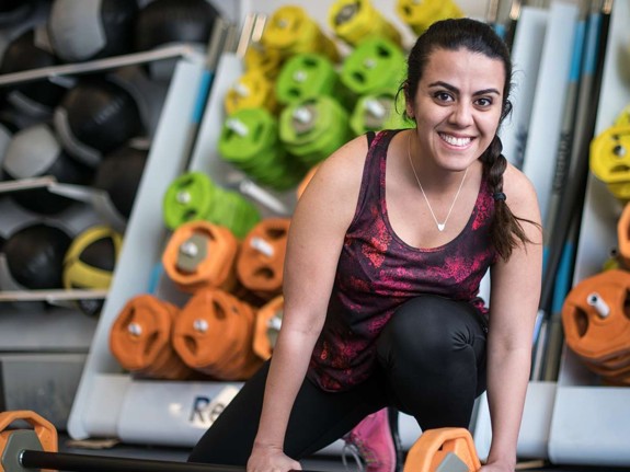 Sonia i träningskläder intill gymutrustning