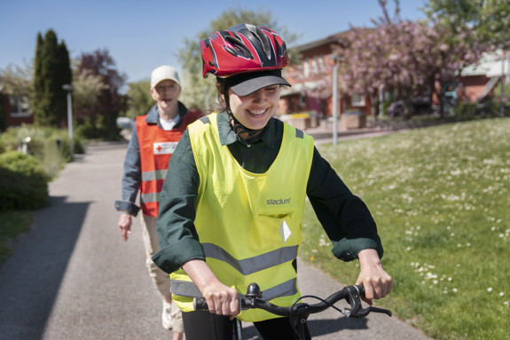 Nahid Bahadrian cyklar med volontär i bakgrunden