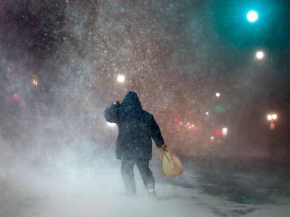 Man är ute och går i oväder med snö