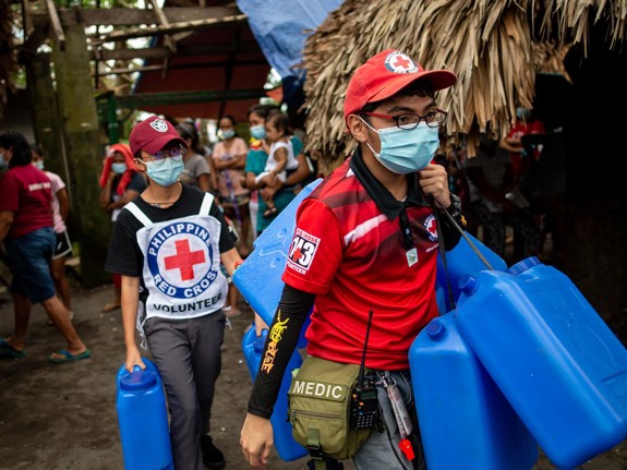 Röda Korset-volontärer med blå dunkar.