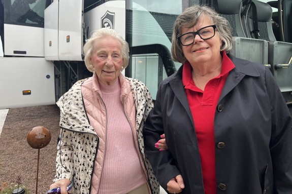 Vår sponsor Gunila Hammarberg och Ann Werthén från Röda Korset Habo utanför bussen. En pensionär hissas ombord på bussen från med hjälp av rullstolsrampen.