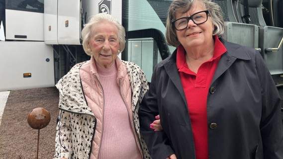 Vår sponsor Gunila Hammarberg och Ann Werthén från Röda Korset Habo utanför bussen. En pensionär hissas ombord på bussen från med hjälp av rullstolsrampen.