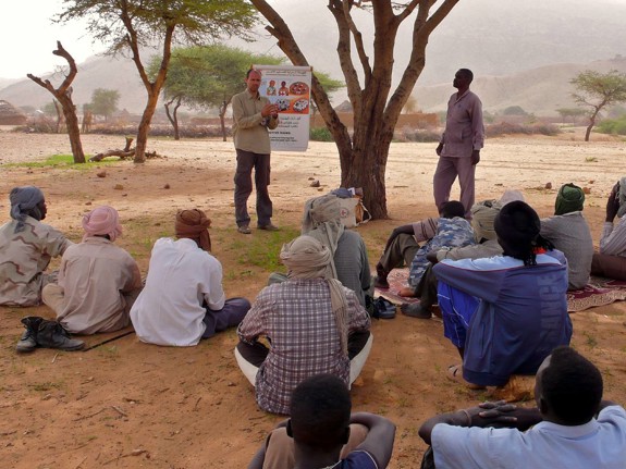 Grupp sitter under träd och utbildas i folkrätt och skydd