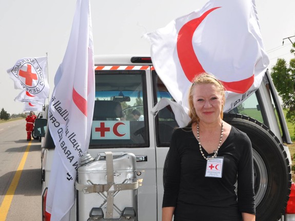Åsa Jansson står vid Röda Korsets flagga