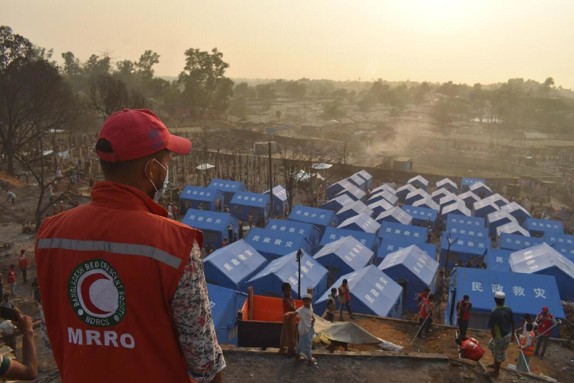 Nyuppbygda tält i kontrast till nedbrunnet område - Bangladesh 2021