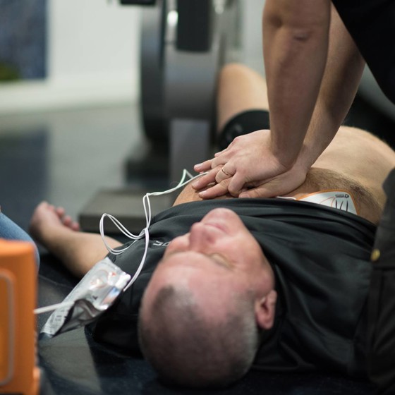 Man har fått hjärtstopp och får hjälp med hjärtlungräddning, HLR, med hjärtstartare