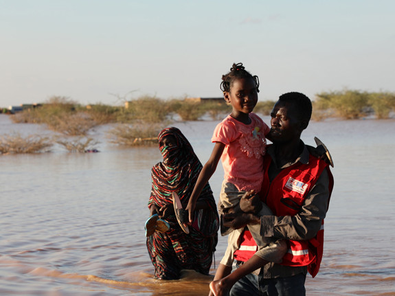Mamma och barn går genom vattenmassor