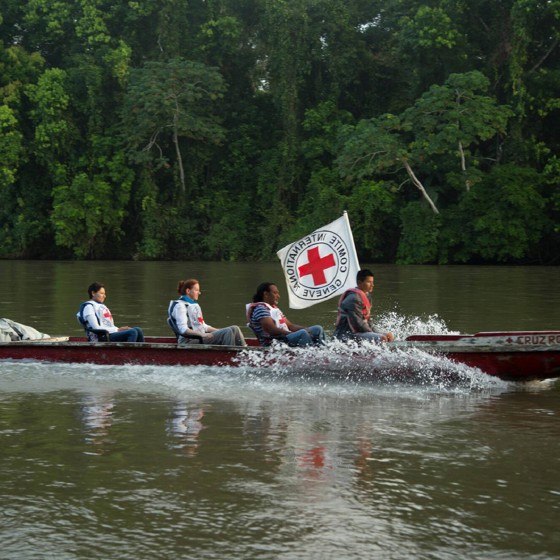 Långsmal båt med Röda Korset-flagga