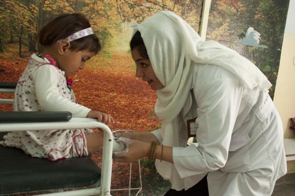 Flicka får benprotes av Röda Korsets hjälparbetare.