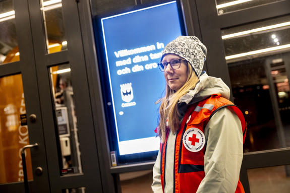 Rödakorsaren Petra Åhlund, som leder första hjälpen-gruppen, tittar in i kameran. Hon står utomhus och har på sig en rödakorsväst.