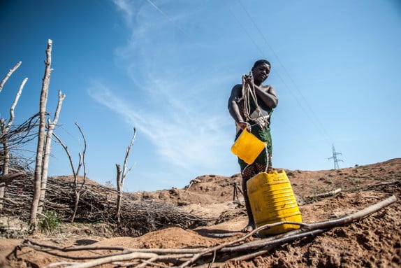 Man i Mocambique hämtar vatten.