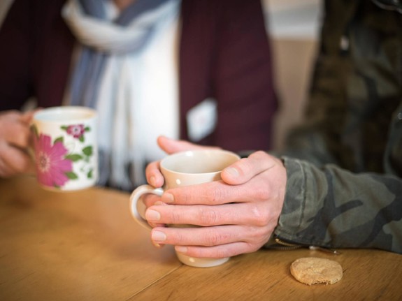 Händer och kaffemuggar.