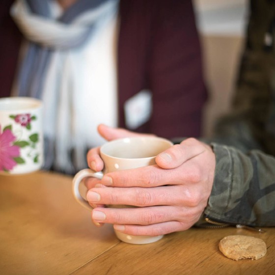 Händer och kaffemugg.