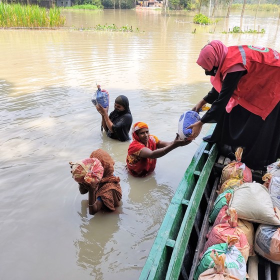 Människor i översvämning får hjälp via båt.