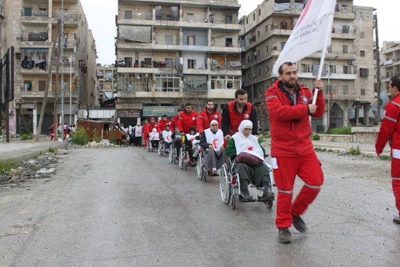 Karavan av rullstolar rullar ut ur Aleppo.