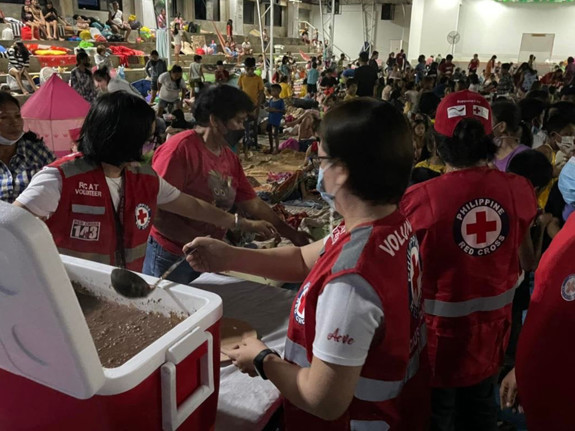 Röda kors volontärer delar ut mat.