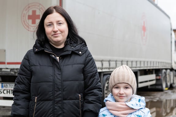 Anna och hennes dotter står framför en lastbil som är märkt med Röda Korset.