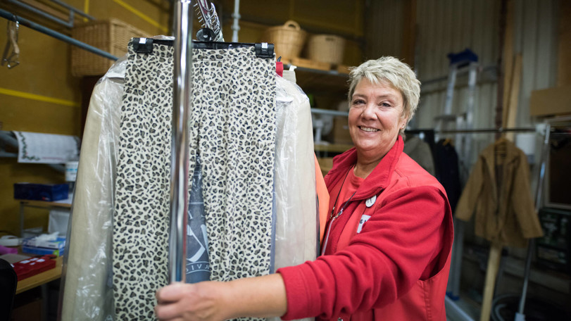 kvinna-flyttar-och-sorterar-kläder-i-second-hand-butik