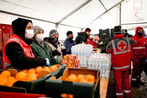 Volontärer delar ut mat till flyktingar.
