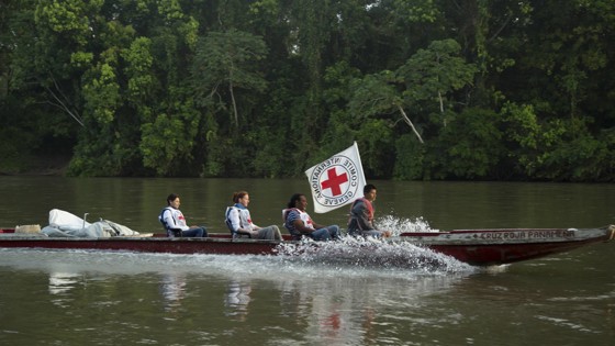 Båt åker över flod med flera passagerare