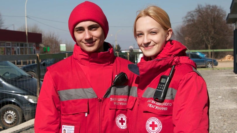 Två rödklädda volontärer i Ukraina